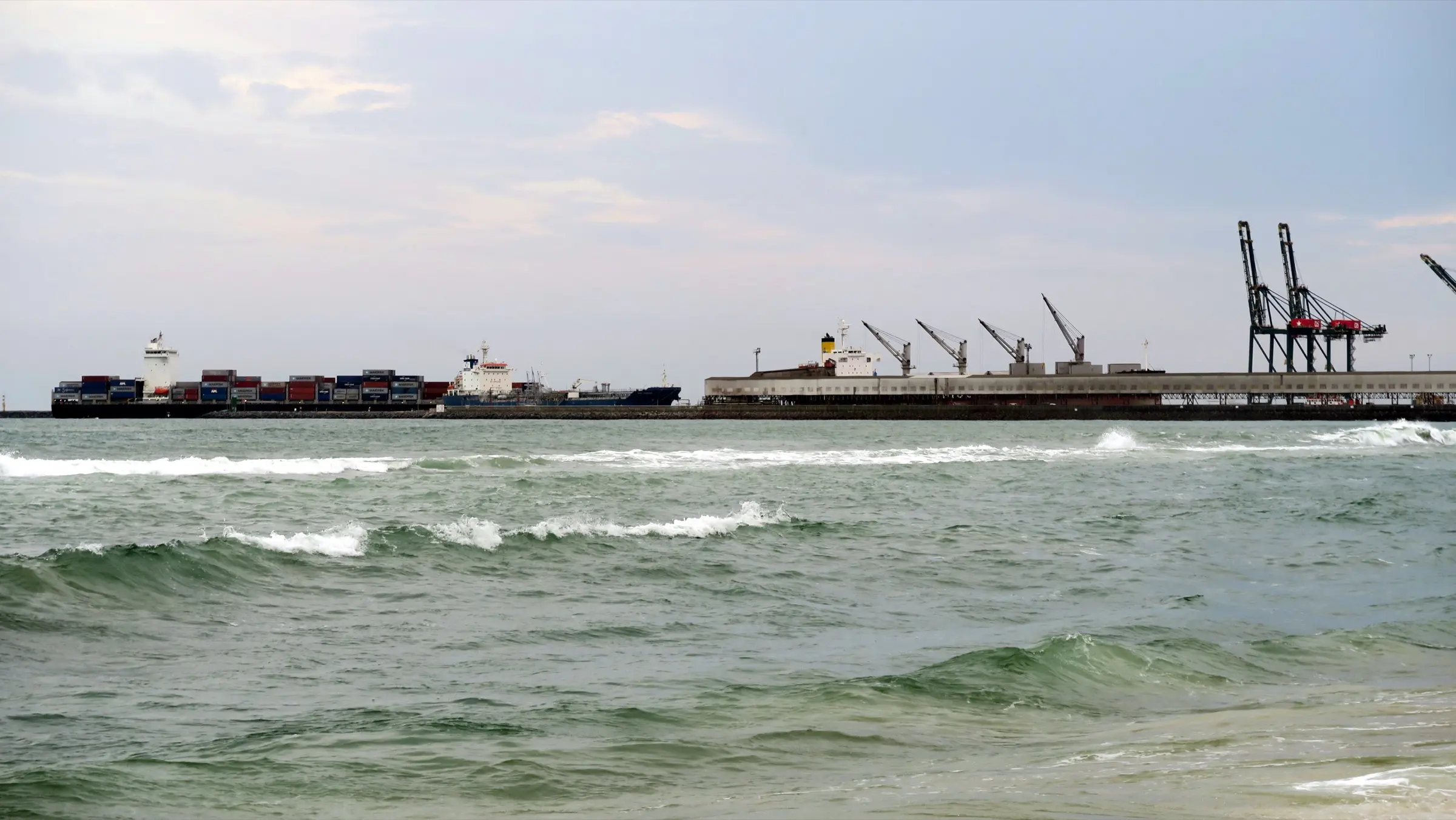 Container ships and gantry cranes at the Port of Lomé, seen from the shore